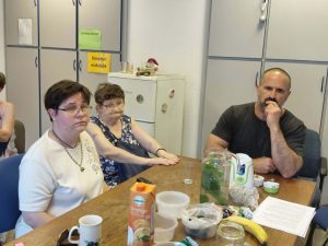 Három résztvevő figyelmesen hallgatja a klubvezető előadását