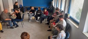 Félkörben jeltolmácsaink látszanak , ahogy egyik siketvak tagunkkal jelelnek, a hallgatók pedig jegyzetelik pszichológus munkatársunk előadását