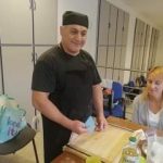 A tészta gyúrásának előkészítése, gyúródeszka, és a tészta kiméréséhez szükséges műanyag lapocska látszik